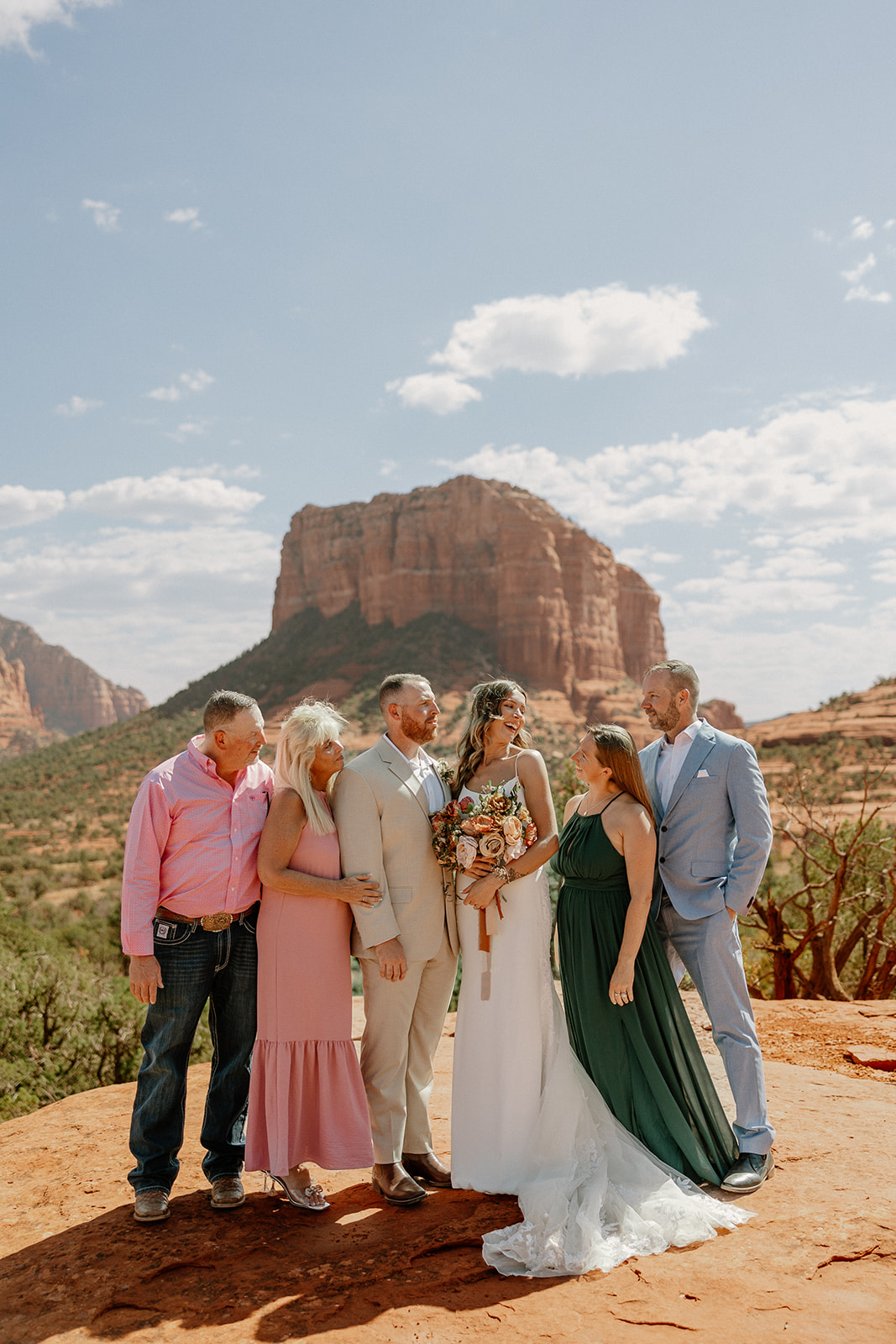 family poses with the bride and groom with the Arizona mountains in the background