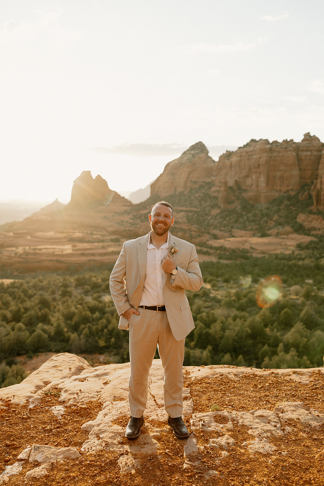 groom poses with the Arizona mountains behind him