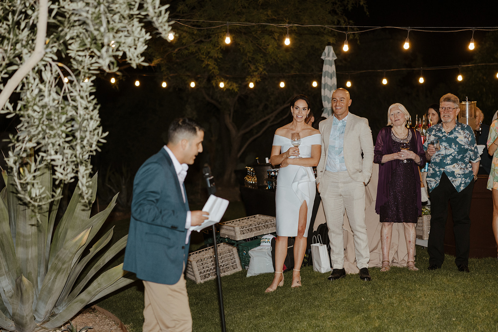 bride and groom look on with their wedding guests as they practice the wedding reception process