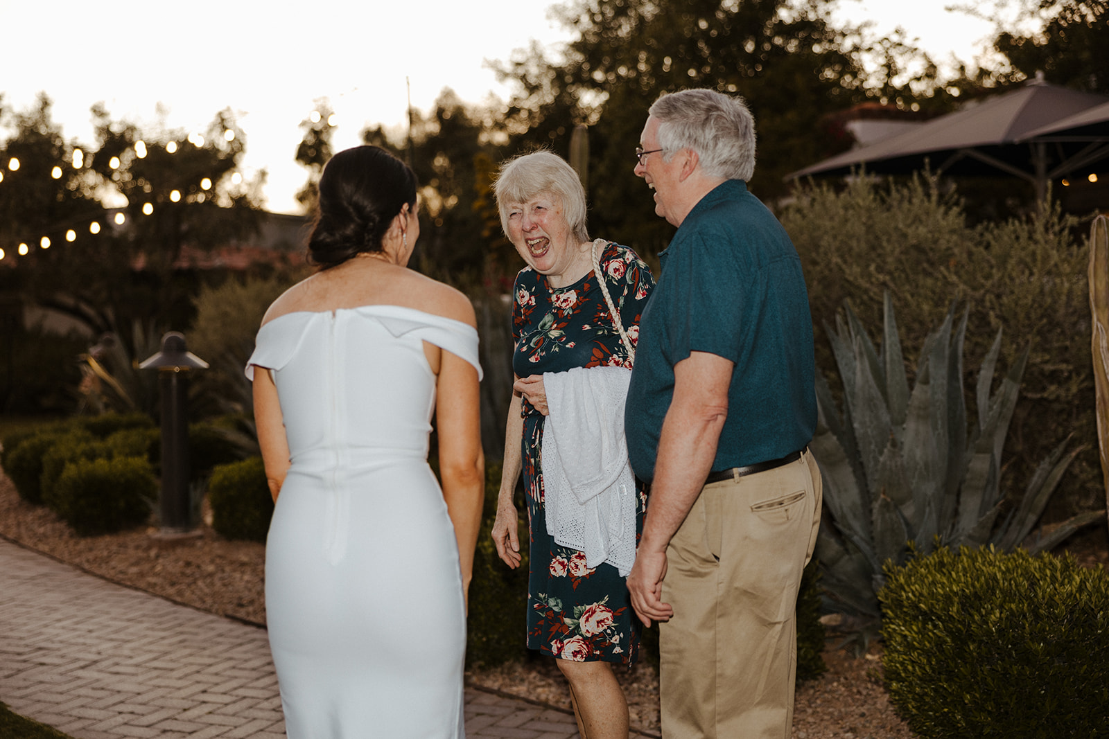 bride shares candid moments with guests during their rehearsal wedding reception