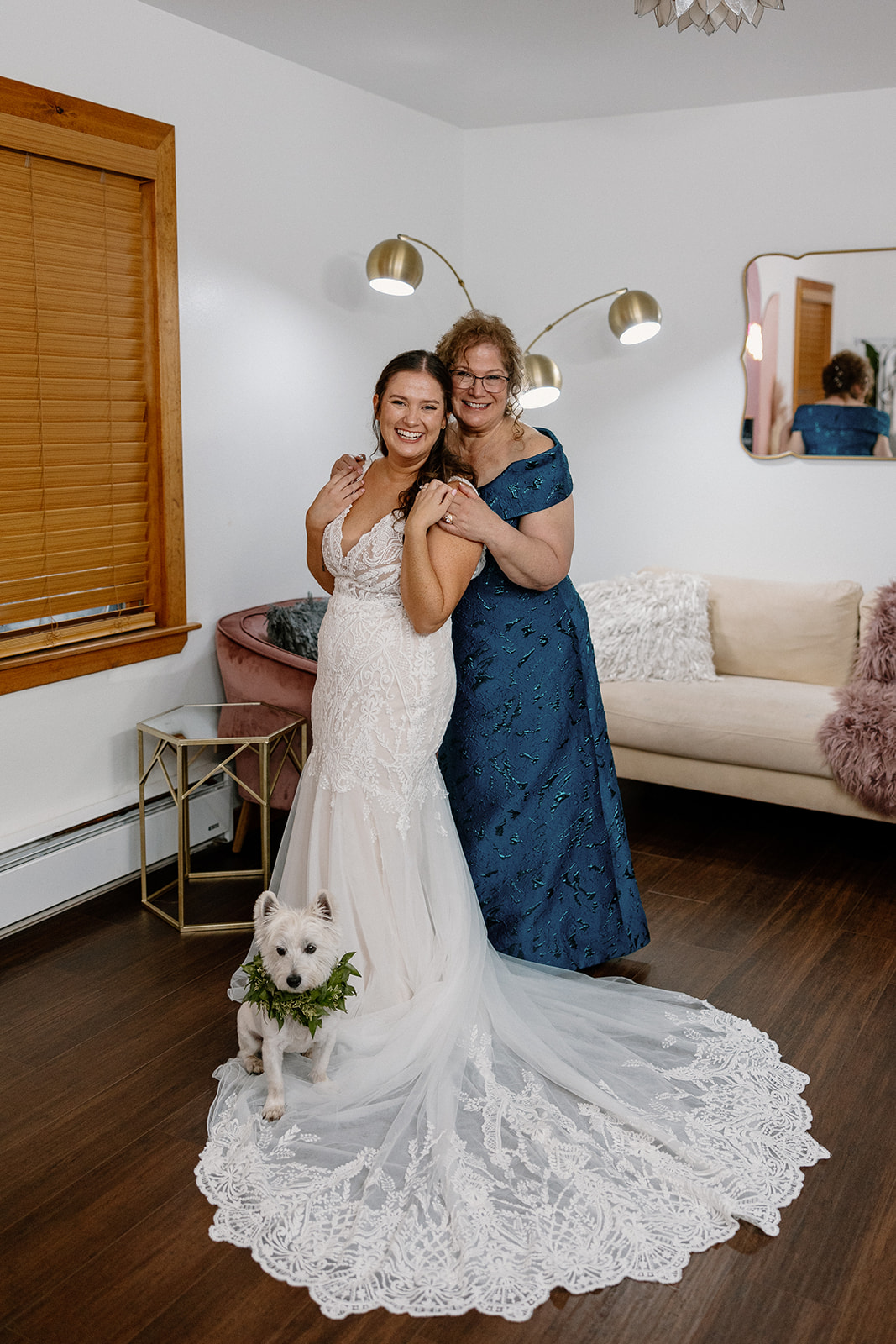 bride poses with her mom and her dog as they get ready for the stunning Arizona wedding day