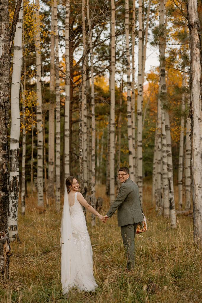 bride and groom stroll through a Arizona field together after their Arizona wedding day