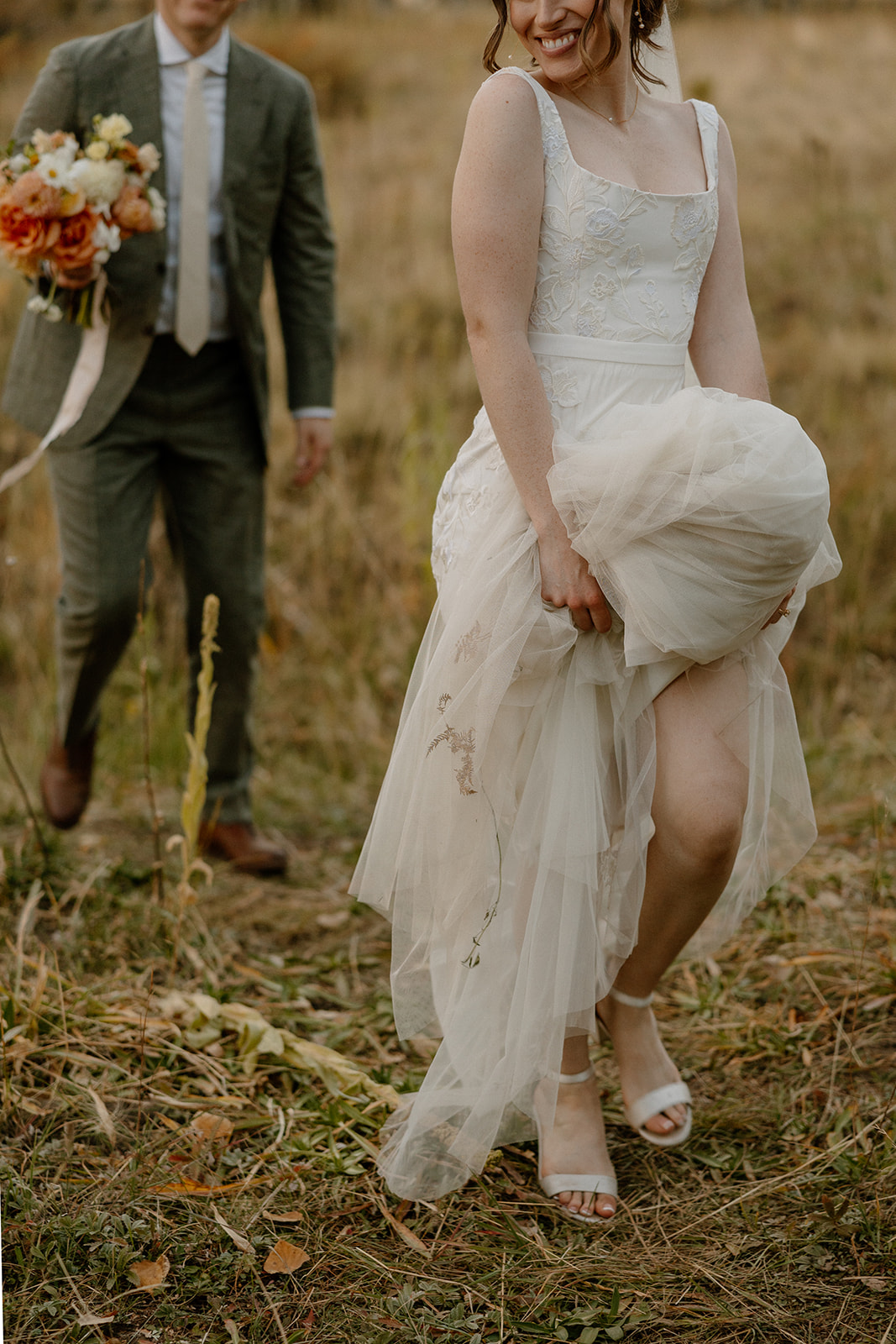 bride and groom stroll through a Arizona field together after their Arizona wedding day