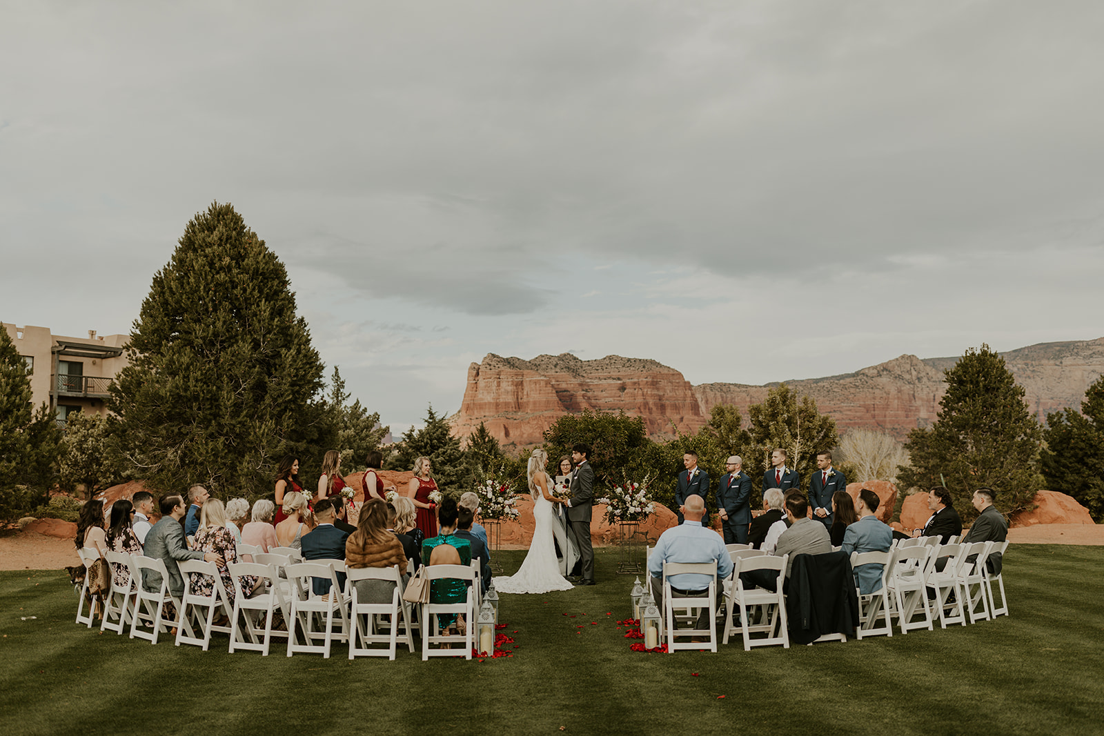 Outdoor summer wedding ceremony at Sedona Golf Resort with red rocks behind couple