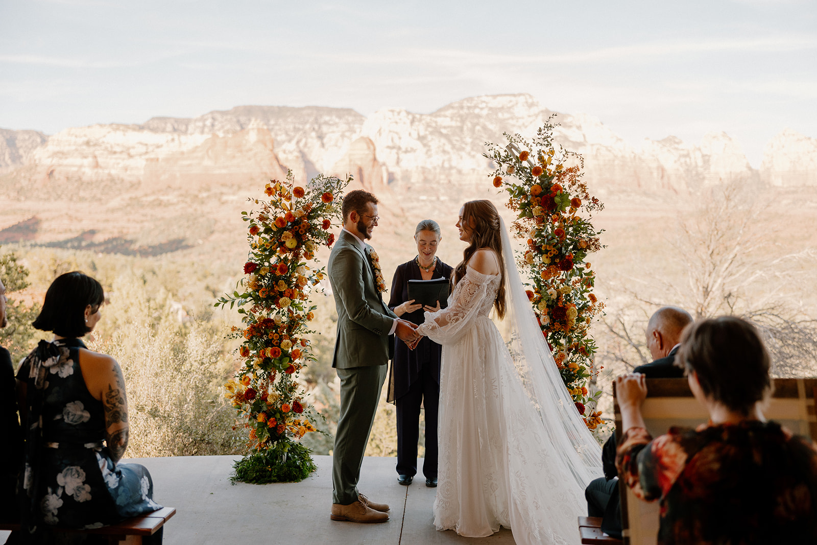 Colorful floral arrangements set up by altar of wedding ceremony at