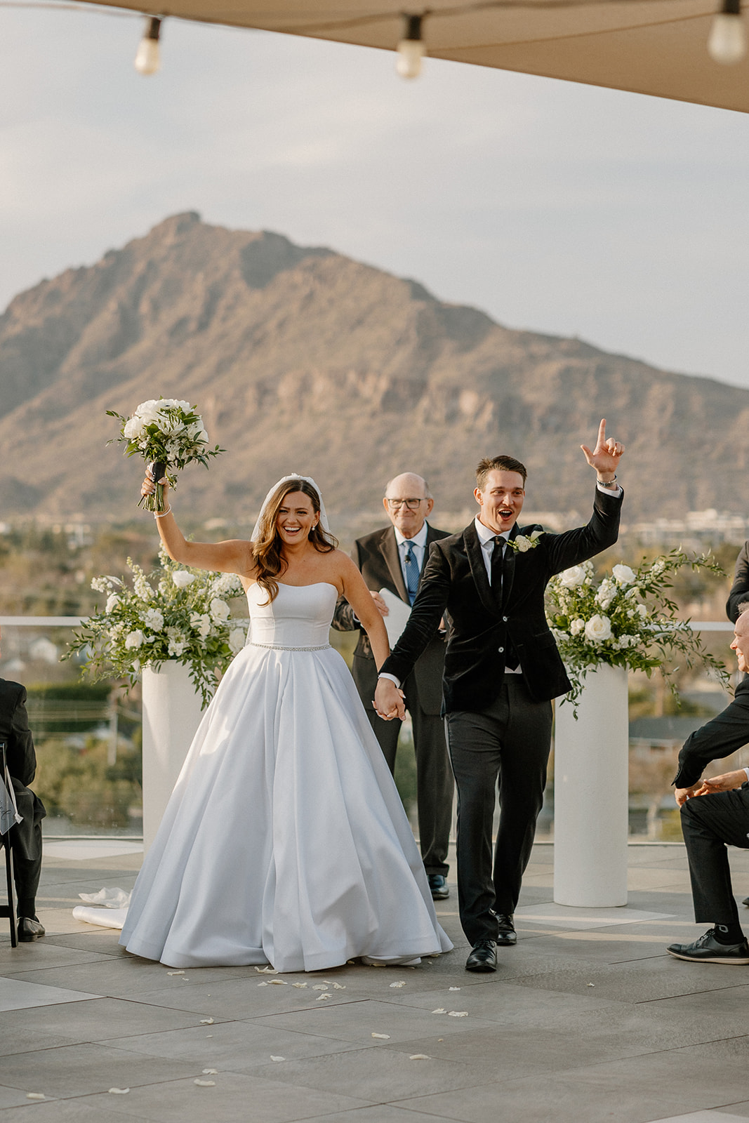 couple with hands in the air celebrating recent marriage