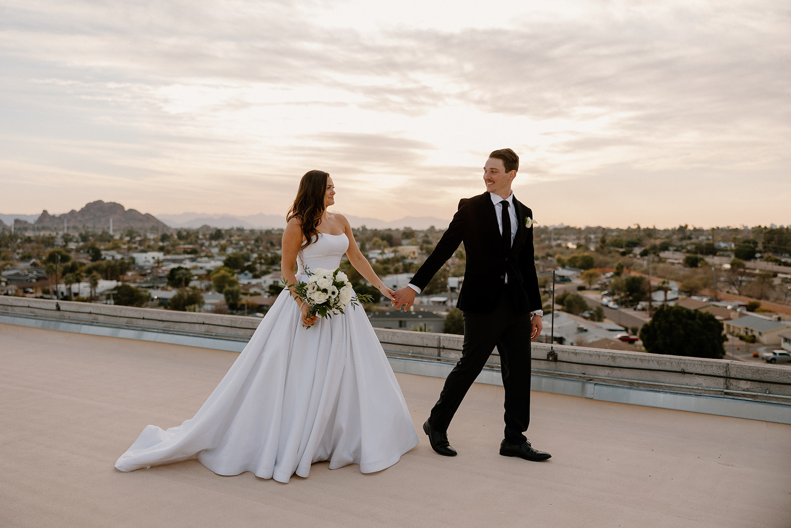 bride and groom on rooftop at Hotel Valley Ho wedding while groom leads bride by the hand