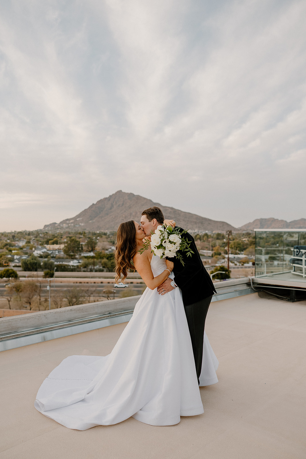 couple kissing on rooftop at Scottsdale hotel after wedding ceremony