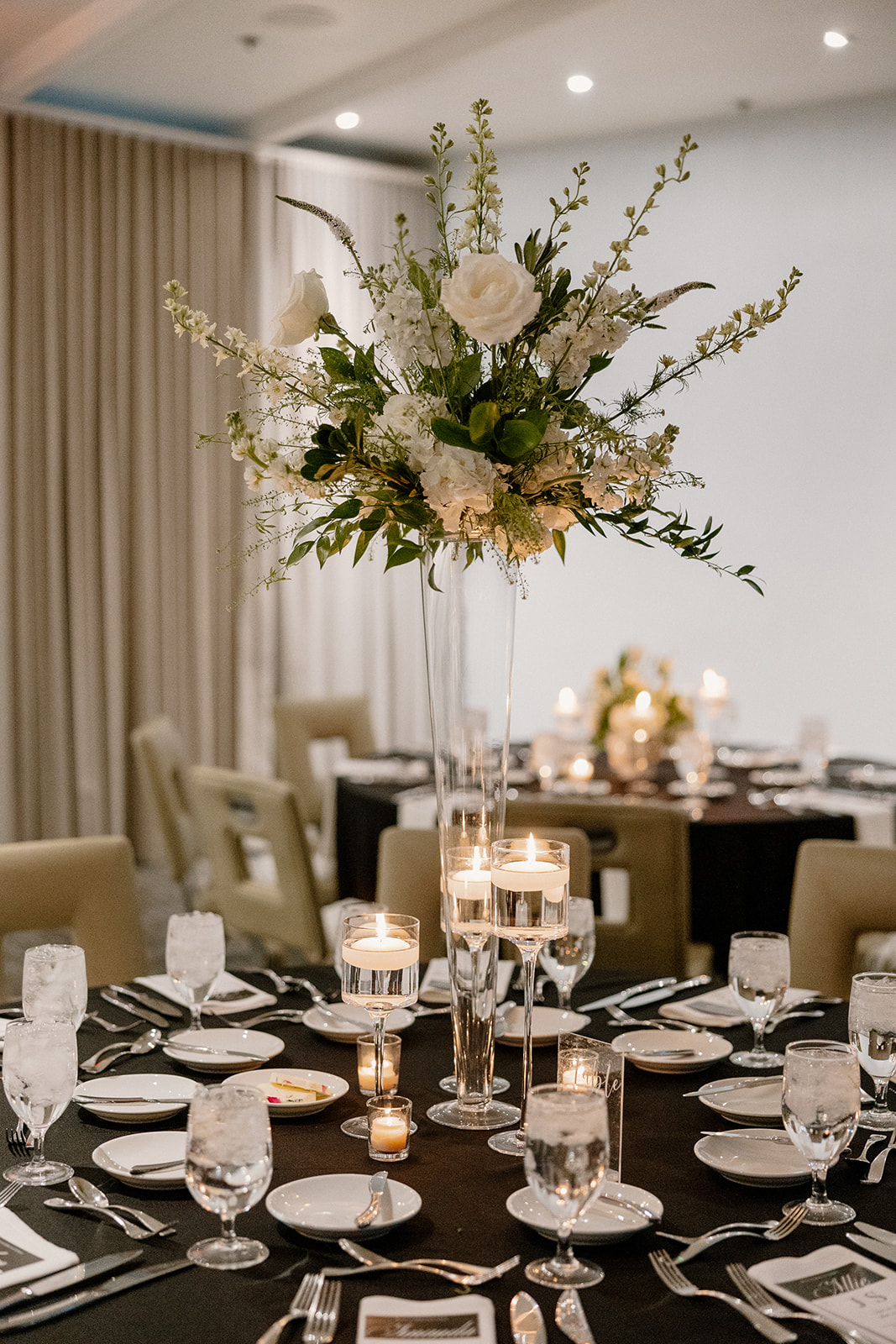 classic white and green floral arrangement as centerpiece in tablescape with black table cloth at Hotel Valley Ho wedding