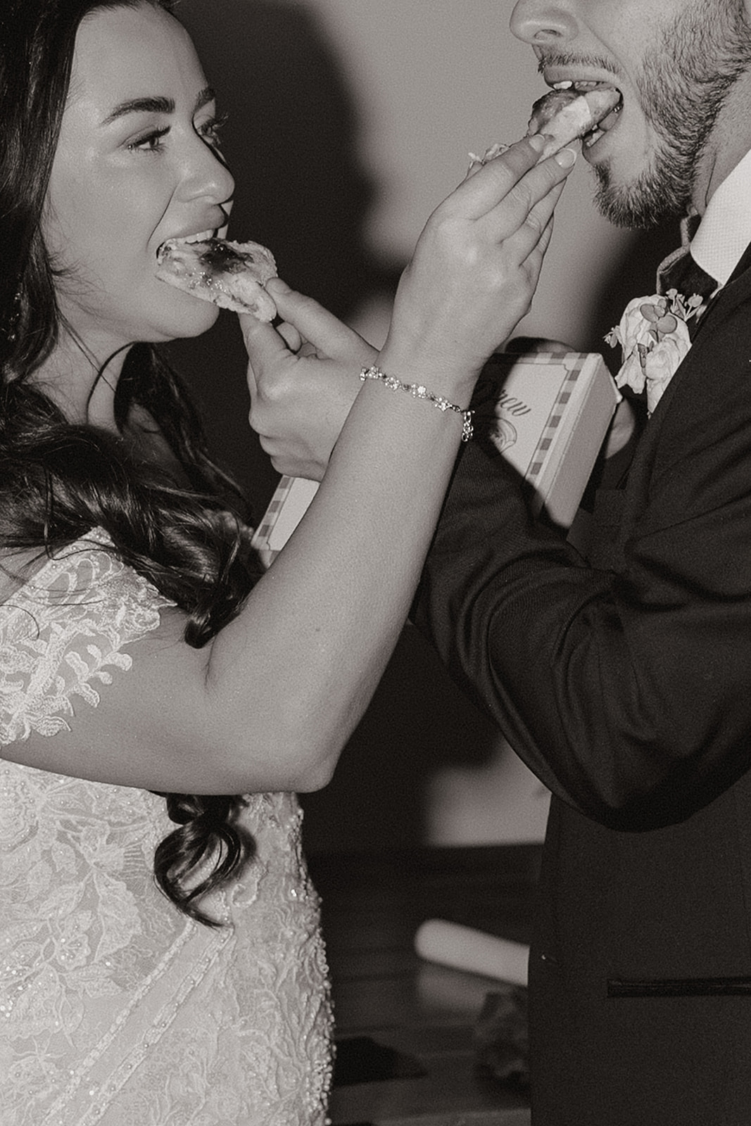 bride and groom share slices of their wedding pizza