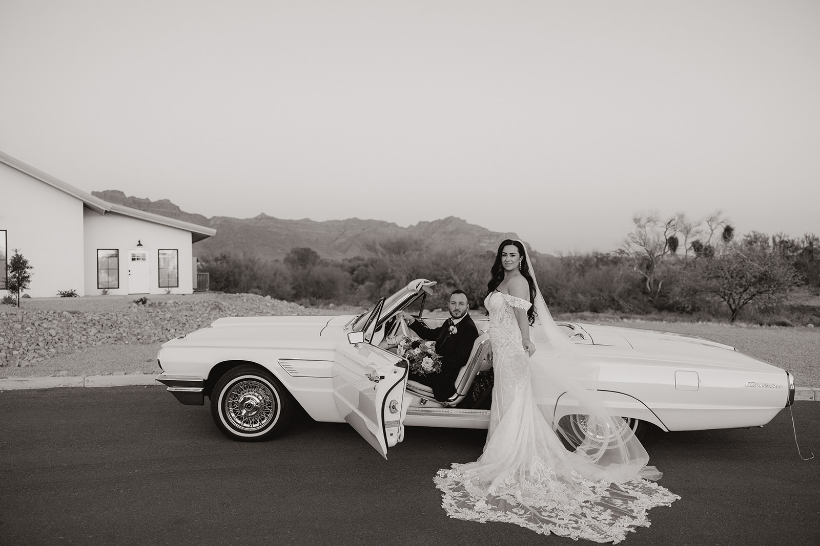 bride and groom pose in a vintage convertible 