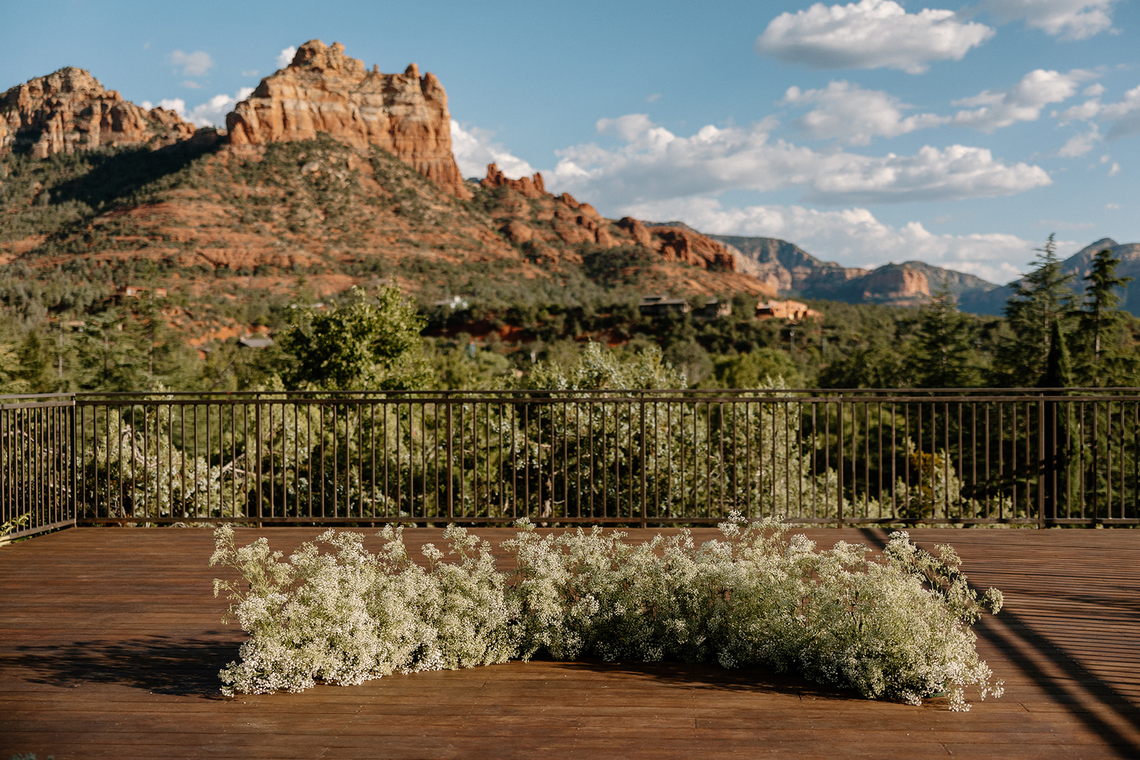 red rocks in background of best wedding venues in Sedona with baby's breath at ceremony site