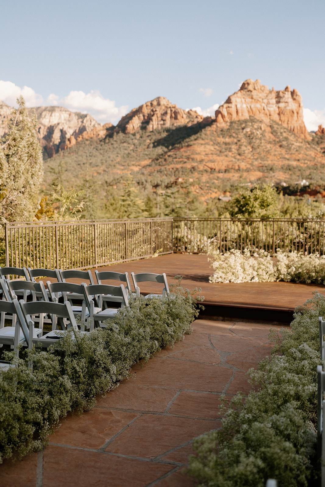 wedding ceremony set up with chairs facing the scenic red rock views with florals down the aisle