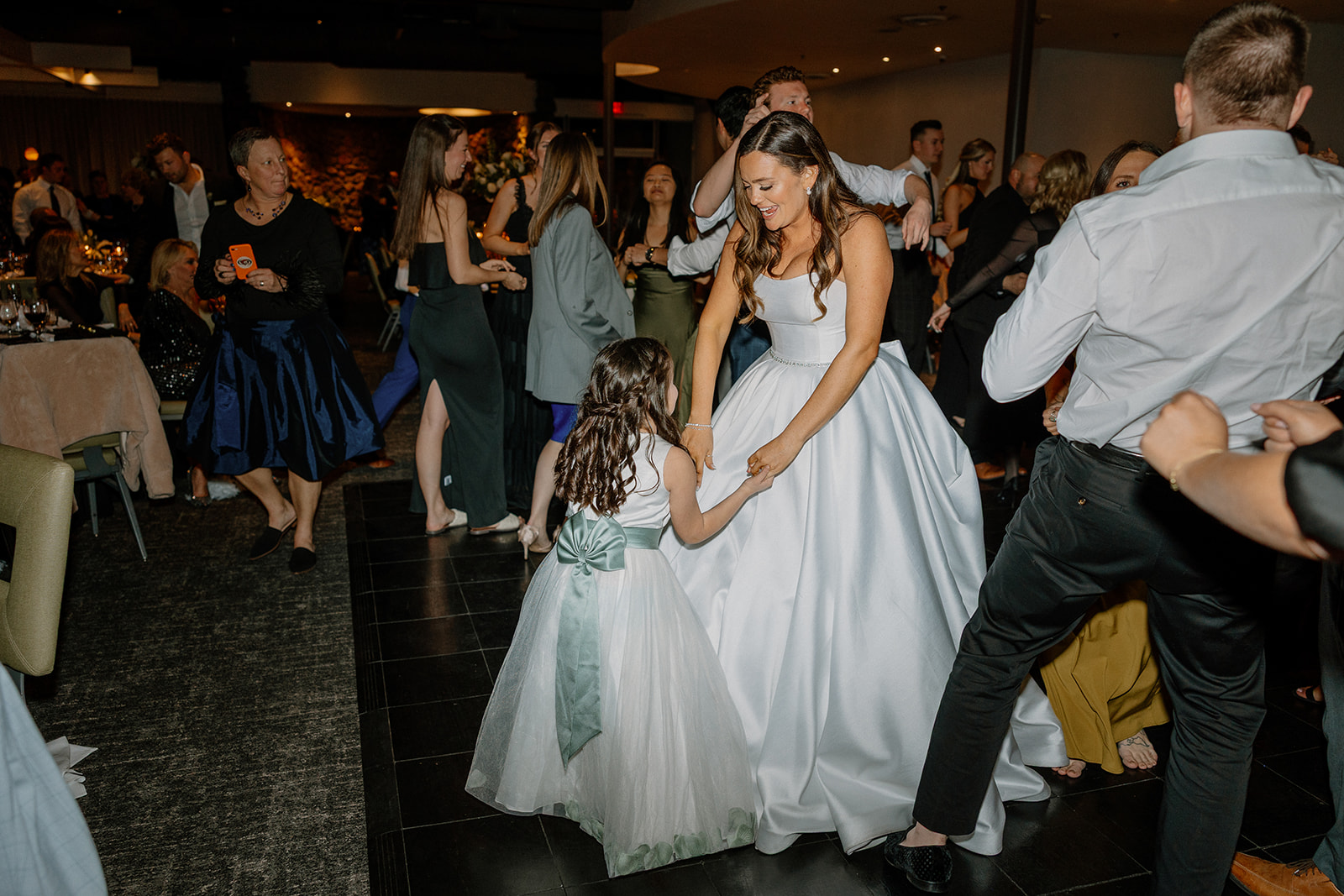 bride dancing with flower girl on dance floor