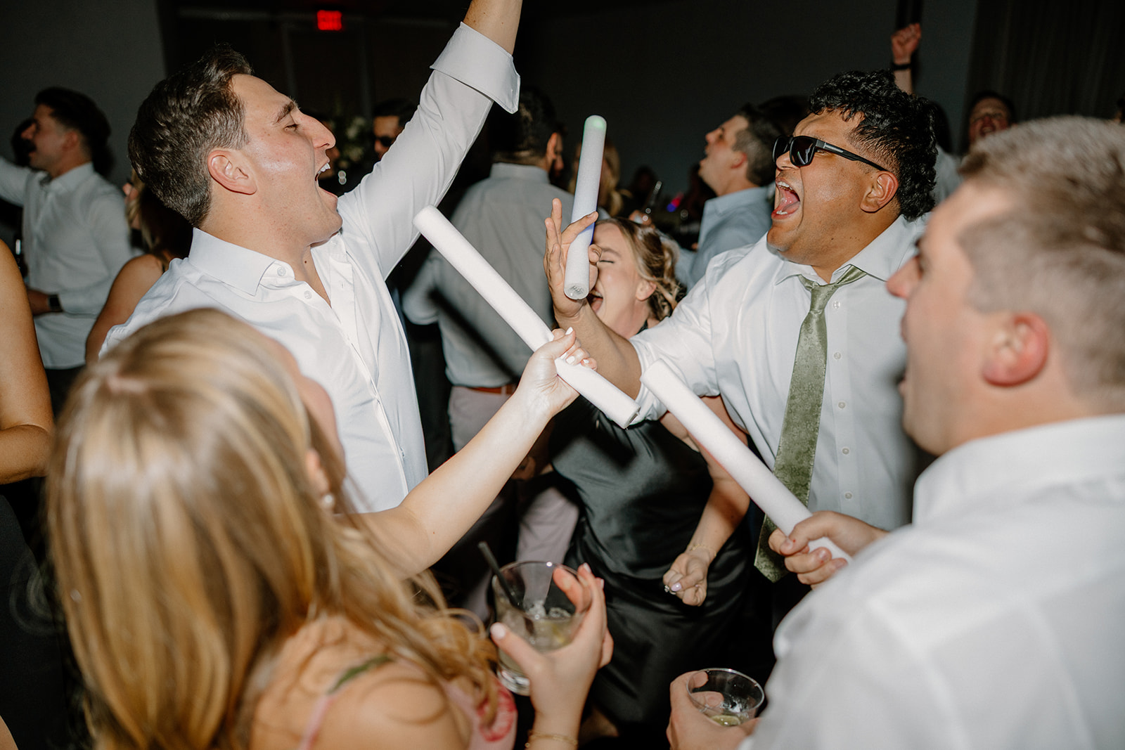 wedding guests dancing holding large glow sticks