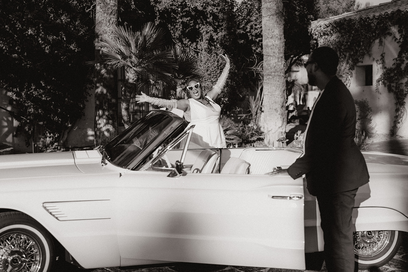 couple get into the drivers and passengers seat of a vintage car during their engagement photos at the royal palms resort