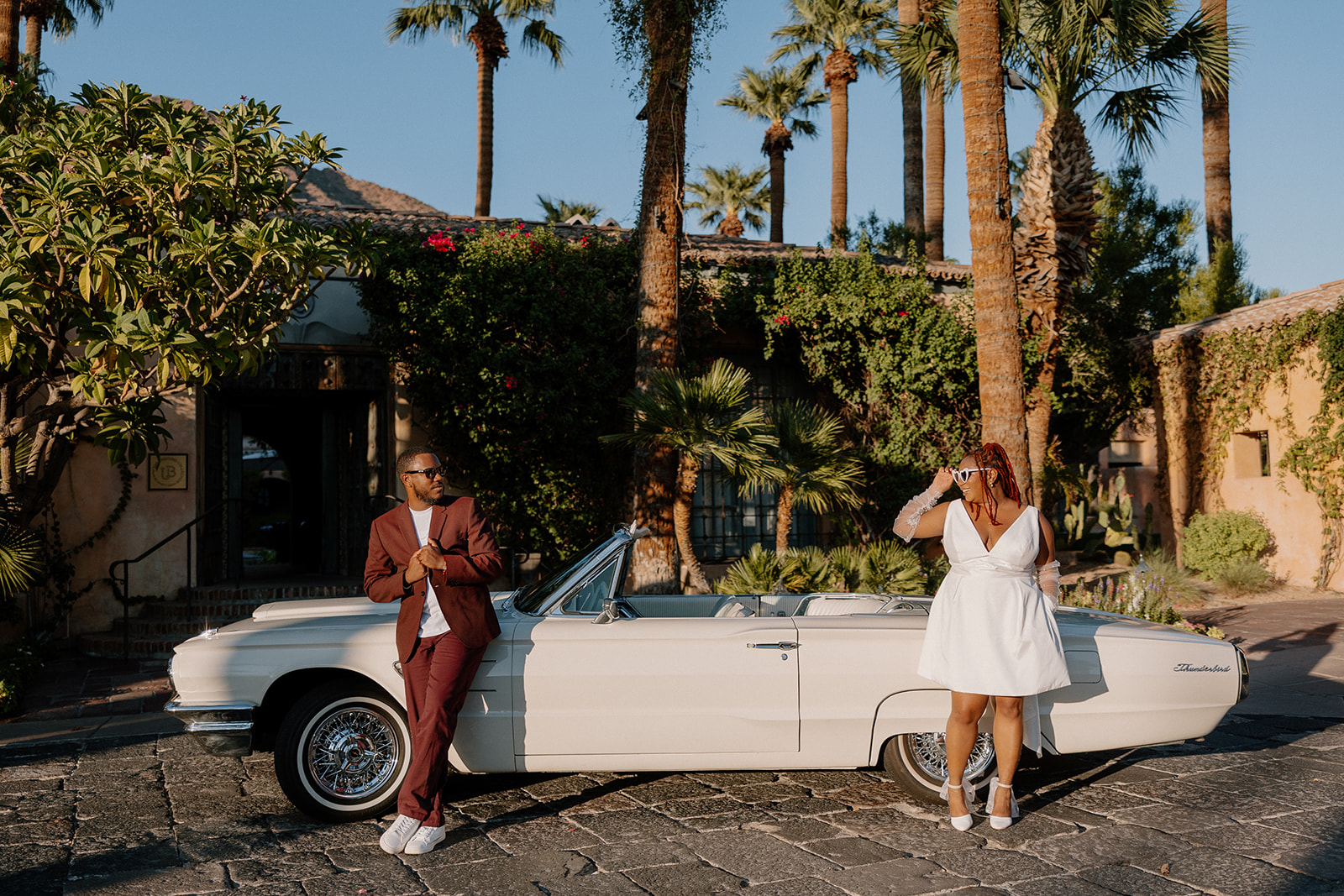 couple lean against in a vintage car during their engagement photos at the royal palms resort