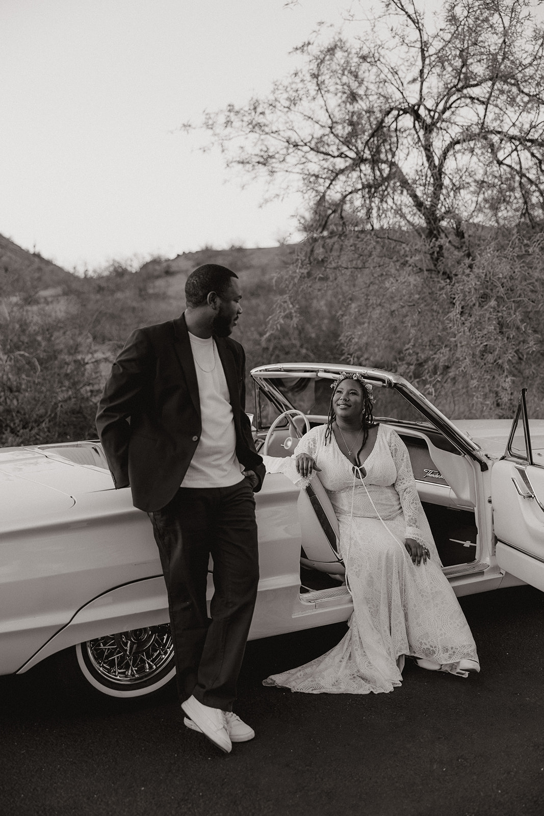 couple pose together in a vintage car during their engagement photos at the royal palms resort