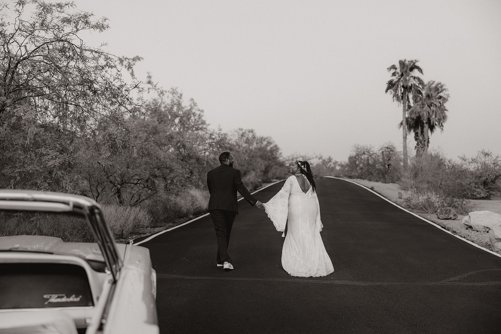 beautiful couple pose with a classic car