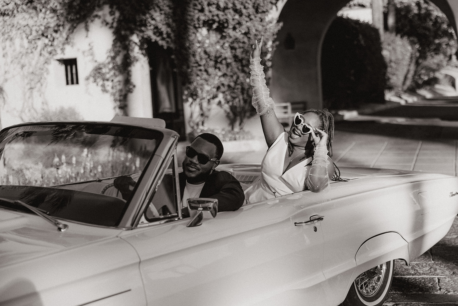 couple pose together in a vintage car during their engagement photos at the royal palms resort