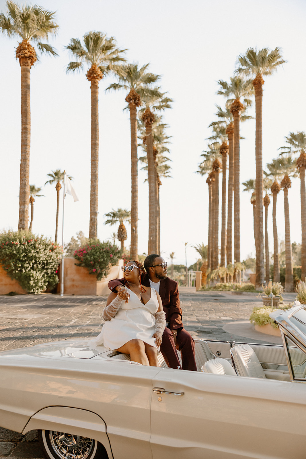 couple pose together in a vintage car during their engagement photos at the royal palms resort