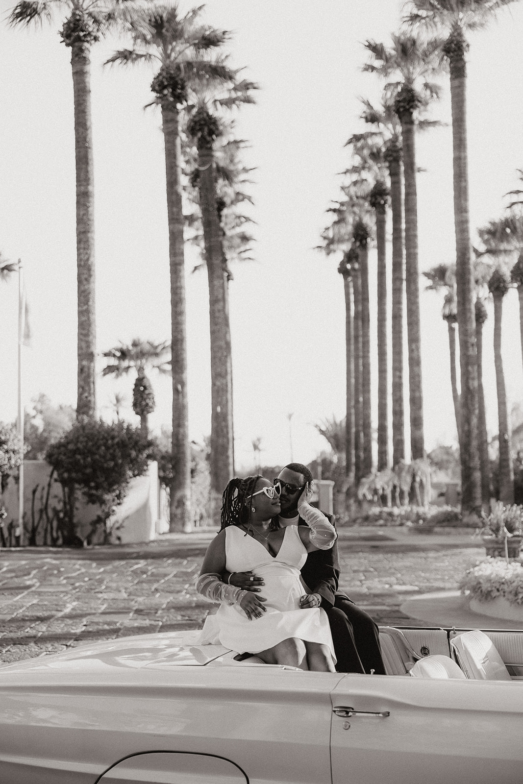 couple pose together in a vintage car during their engagement photos at the royal palms resort