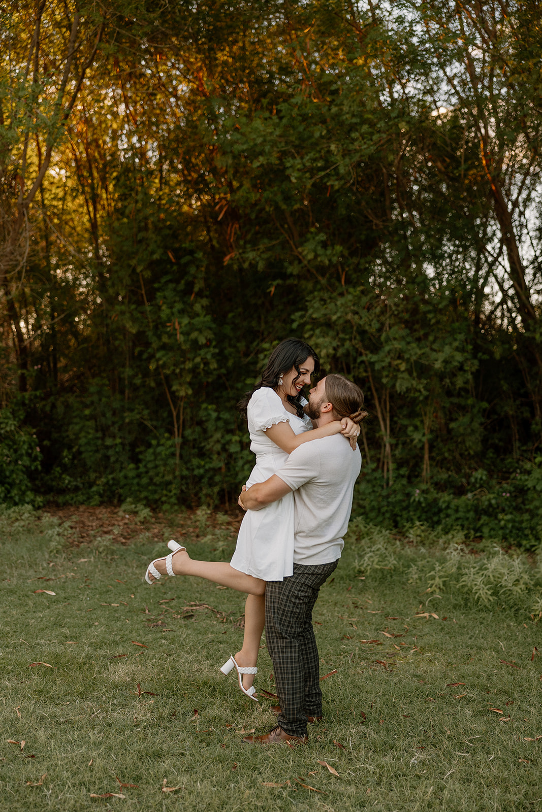 beautiful couple share a romantic kiss together in the greenery during their Mesa Arizona Engagement Photos