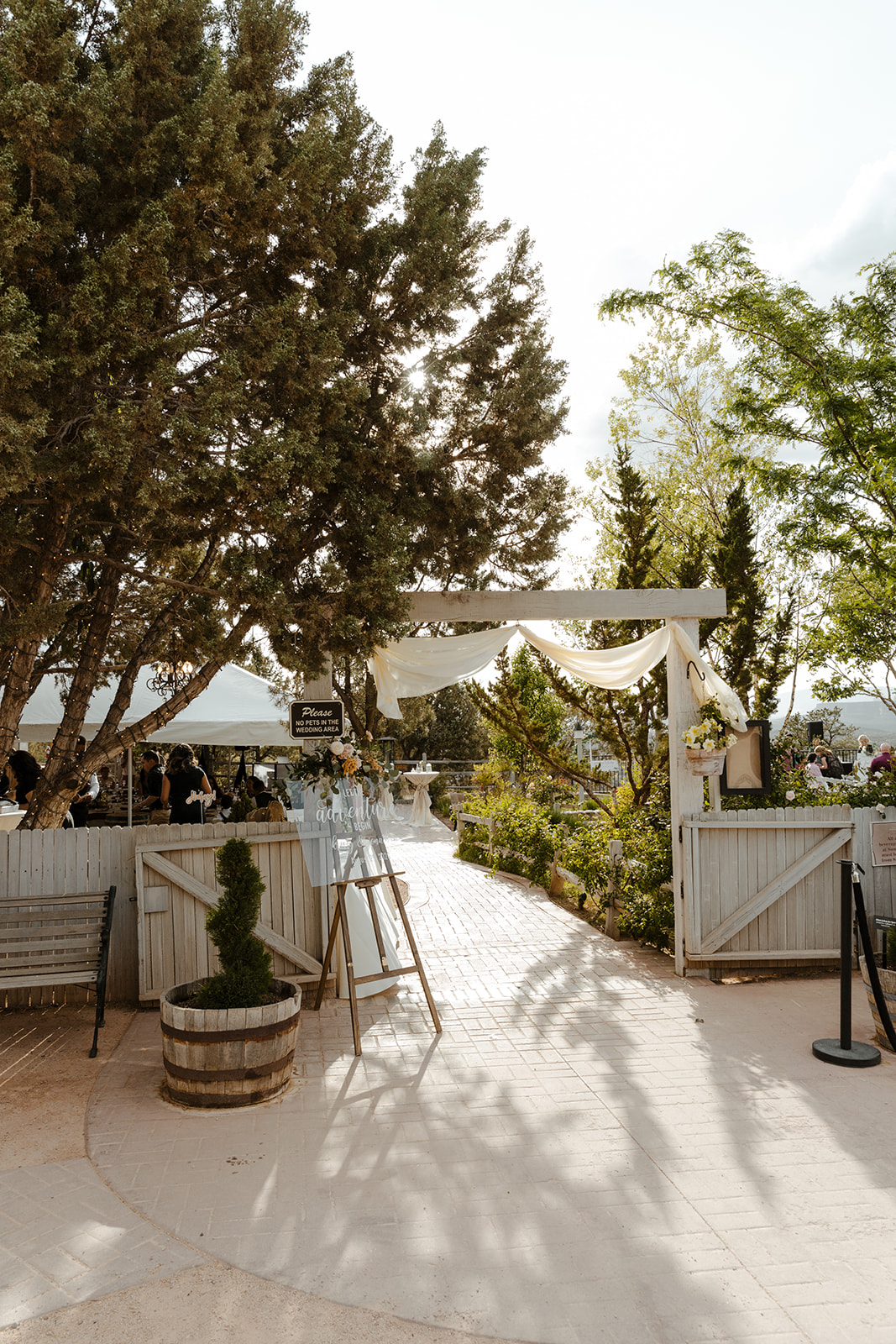Entrance to outdoor wedding reception with decor and white fabric