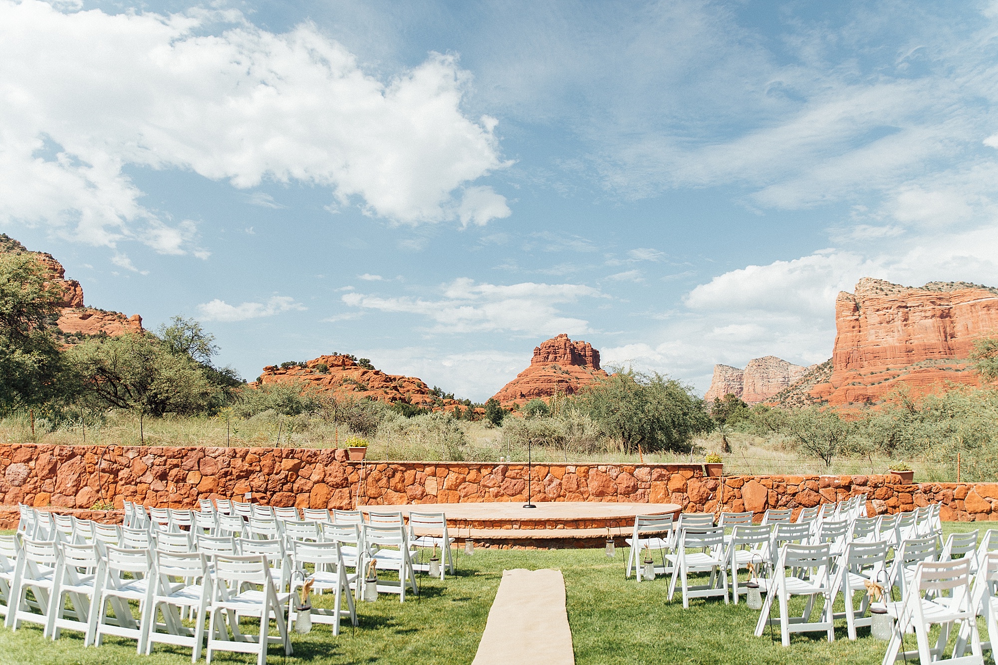 outdoor wedding ceremony set up at Red Agave Resort with white wedding chairs facing the red rock