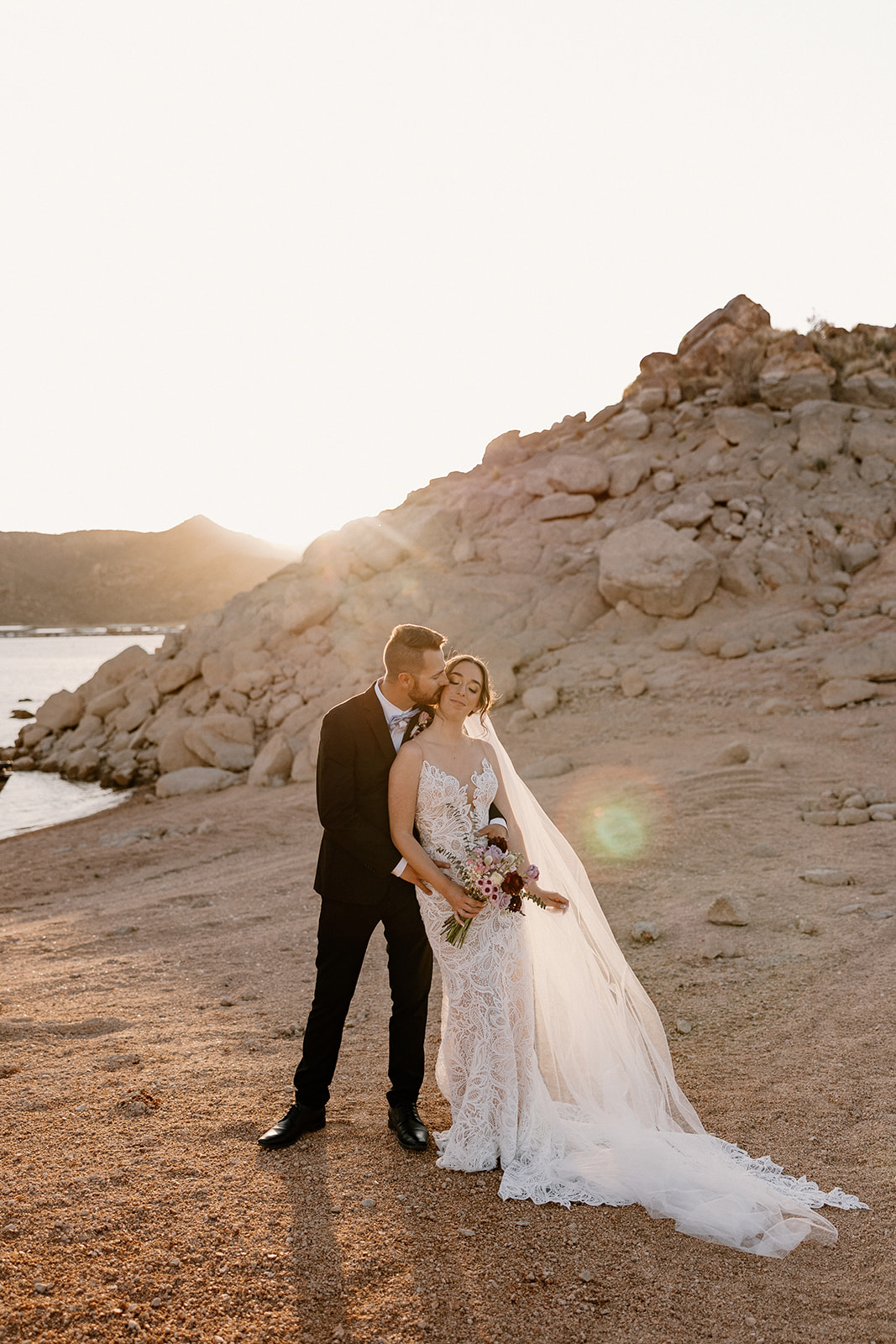 Couple holding hands and laughing during their The Cove at Bartlett Lake wedding, surrounded by sunlit desert views.