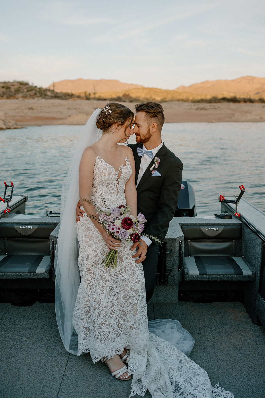 Bride and groom sharing a quiet moment on a boat after their ceremony at The Cove at Bartlett Lake wedding, with golden hour light.