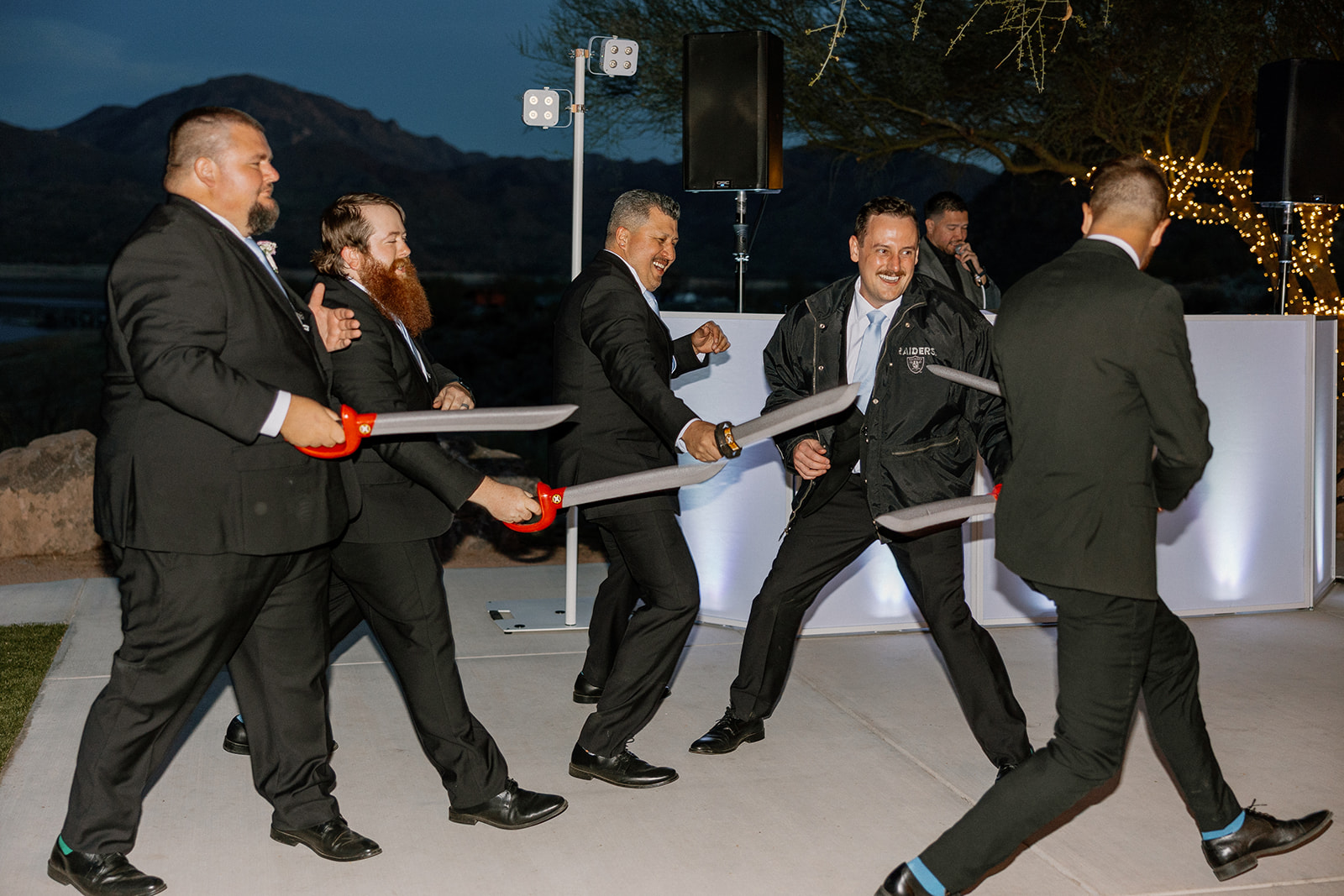 Groomsmen having a playful sword fight on the dance floor at The Cove at Bartlett Lake wedding reception.

