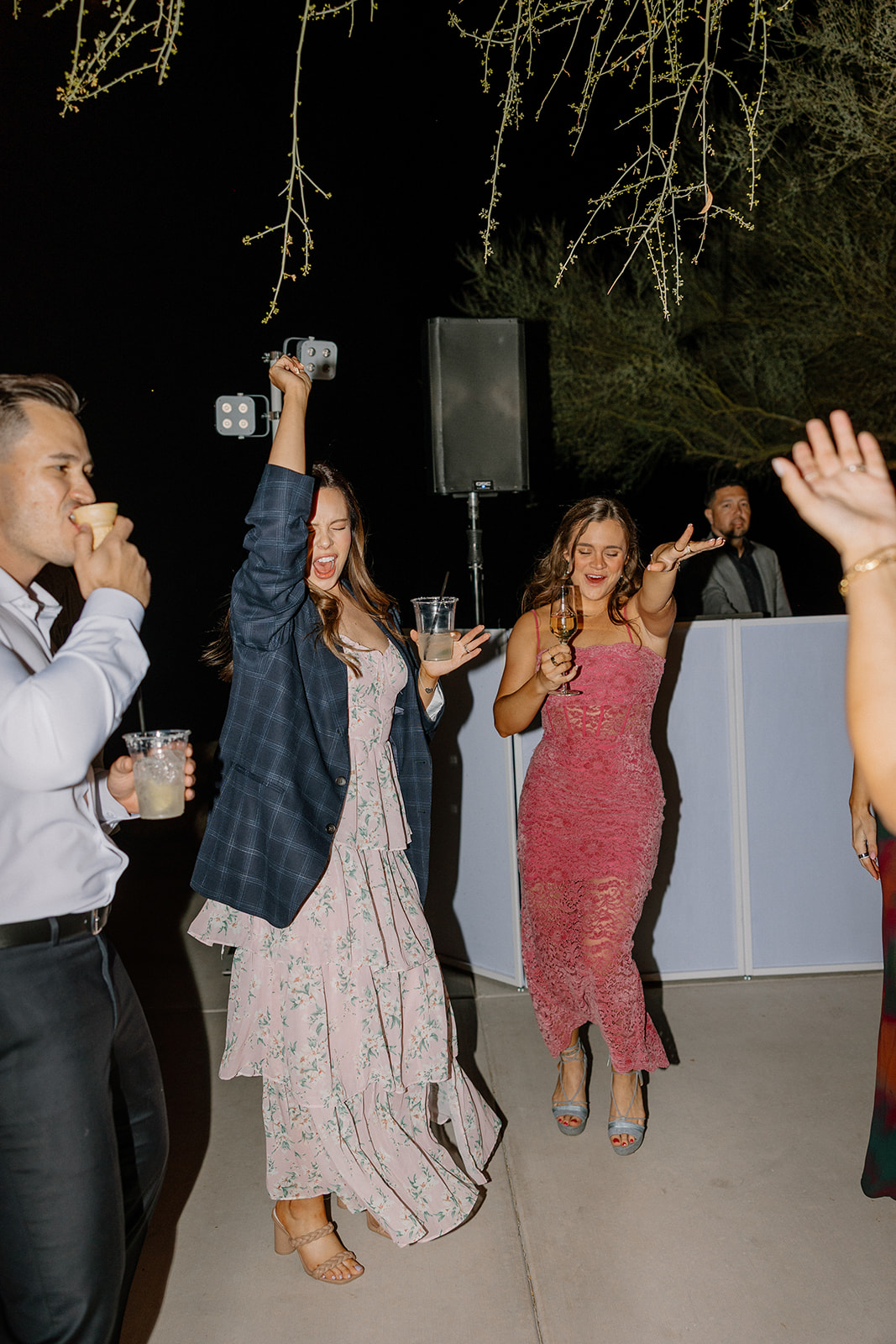 Wedding guests enjoying drinks and dancing under string lights at The Cove at Bartlett Lake wedding reception.

