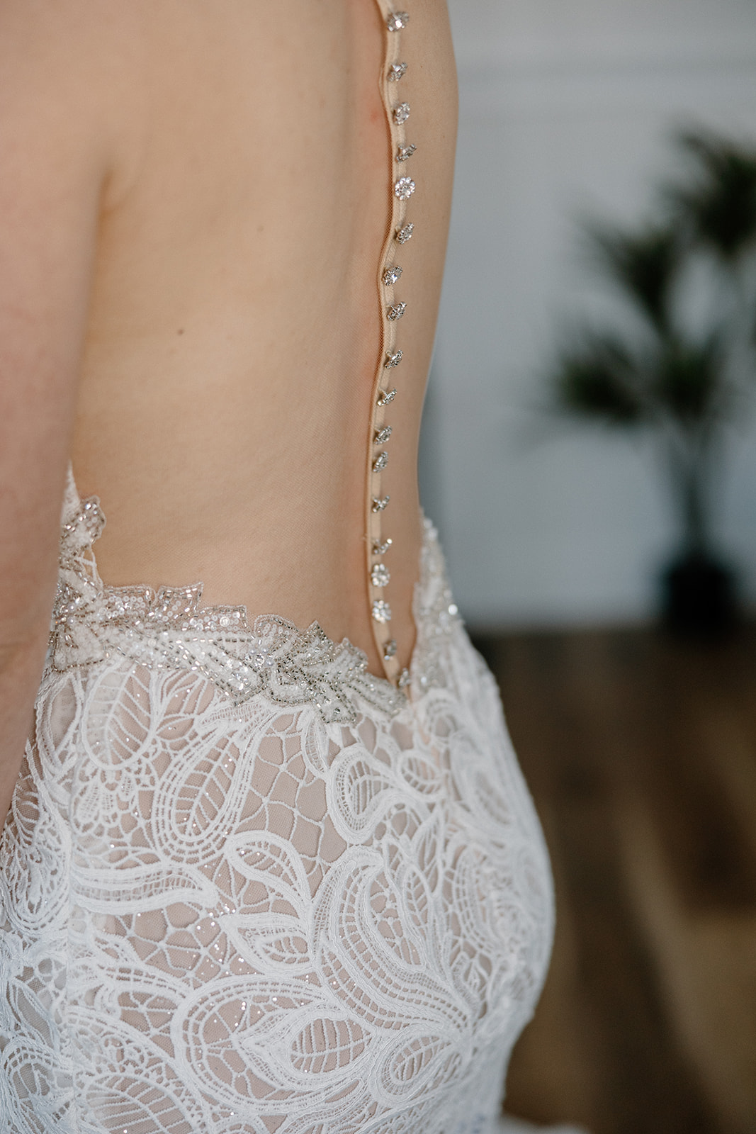 Close-up of intricate lace wedding dress and crystal button details from a bride at The Cove at Bartlett Lake wedding.