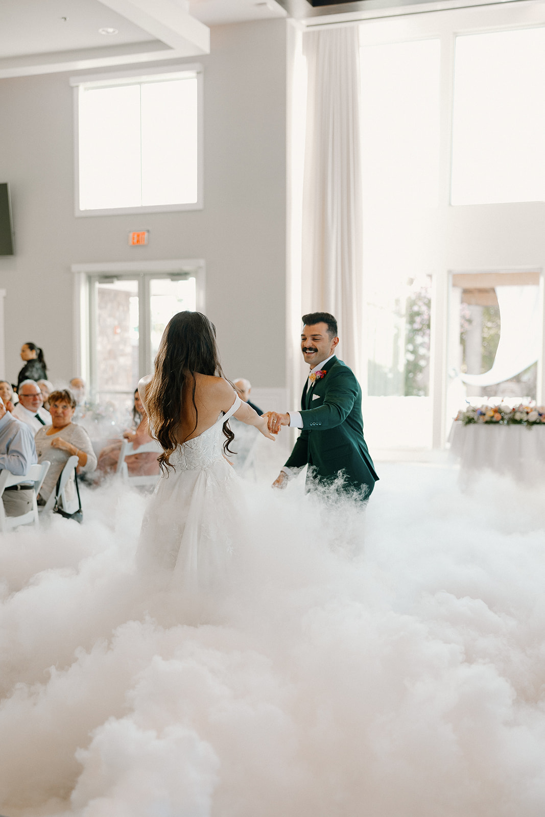 The bride and groom twirl through a cloud machine moment during their first dance at a modern Arizona wedding reception.

