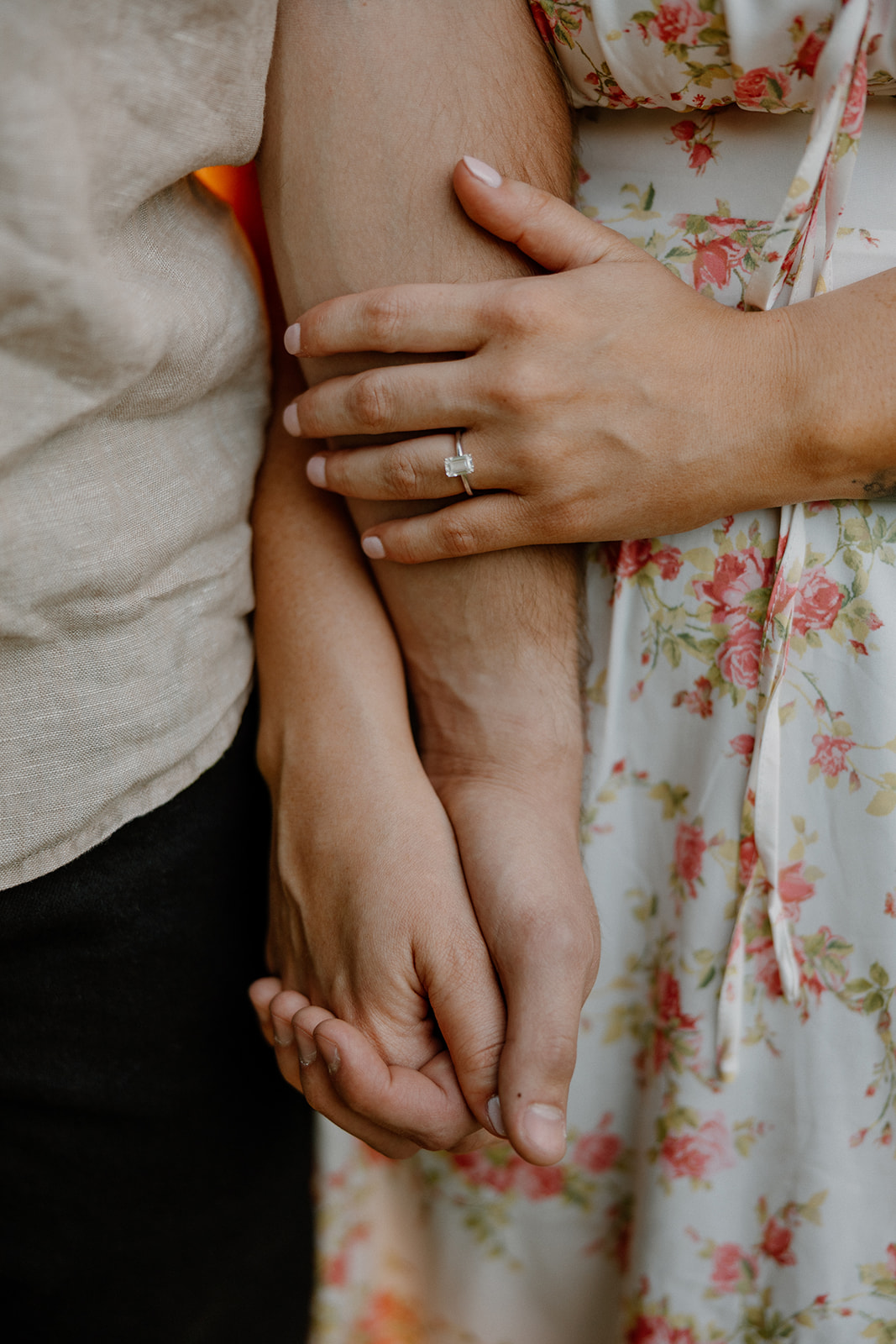 close up of emerald engagement ring on woman's hand