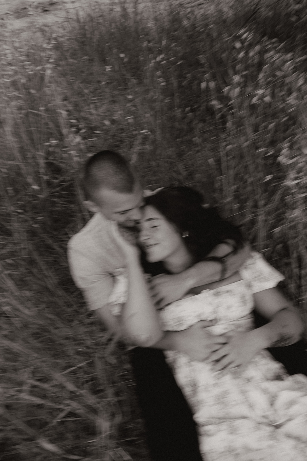 Man and woman laughing in the grass together 