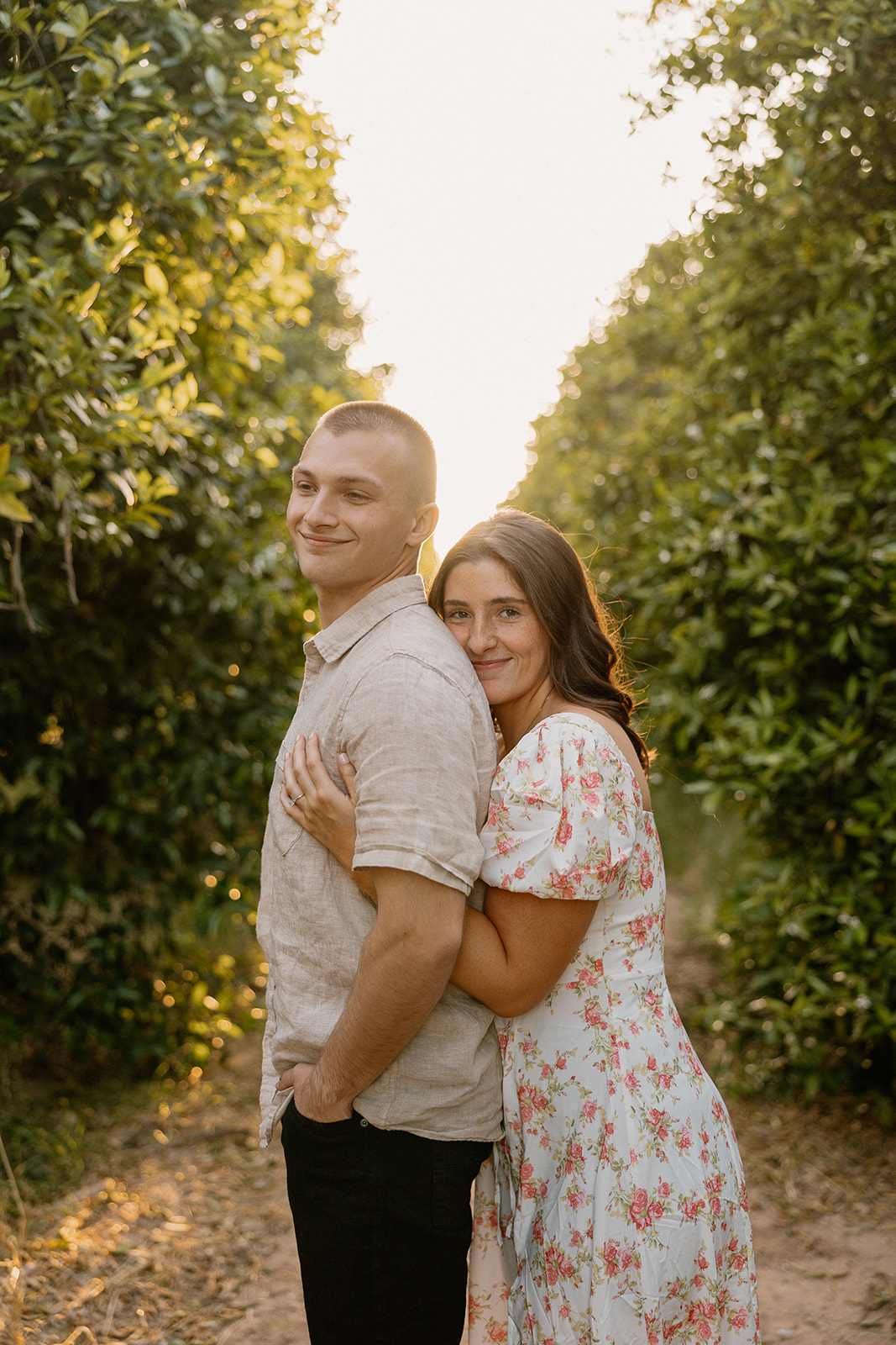 Woman hugging man from behind during orange orchard in Arizona