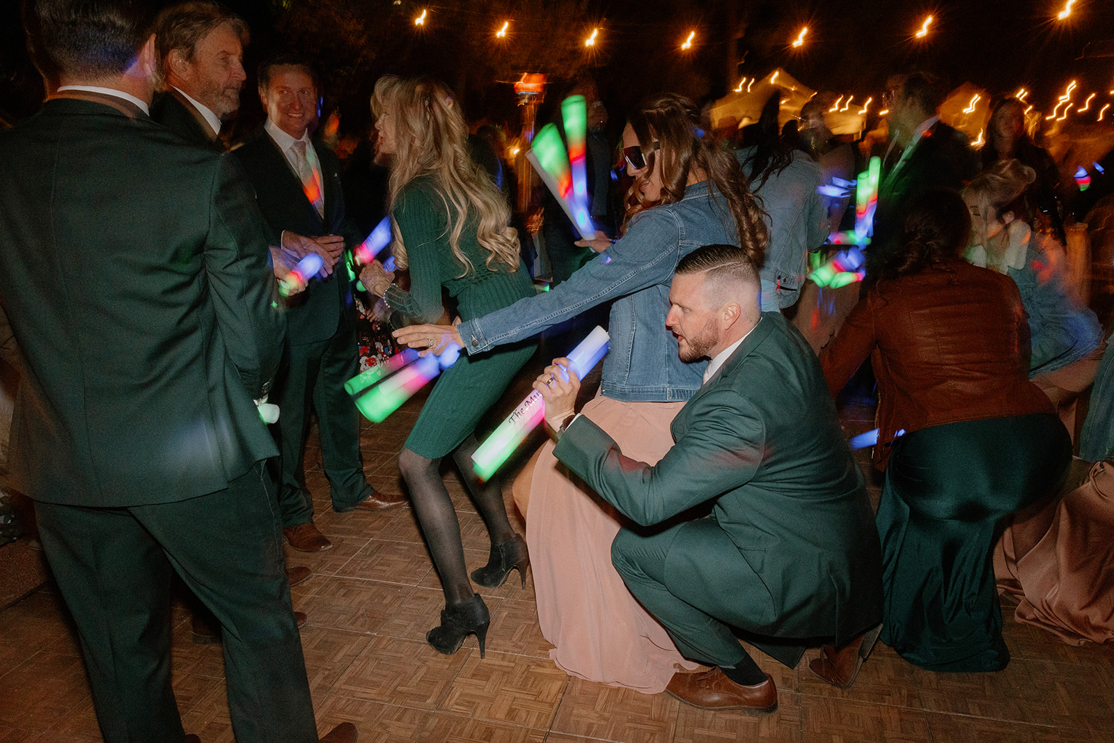 A couple grinds low to the beat, surrounded by friends and laser lights at an Arizona wedding reception.

