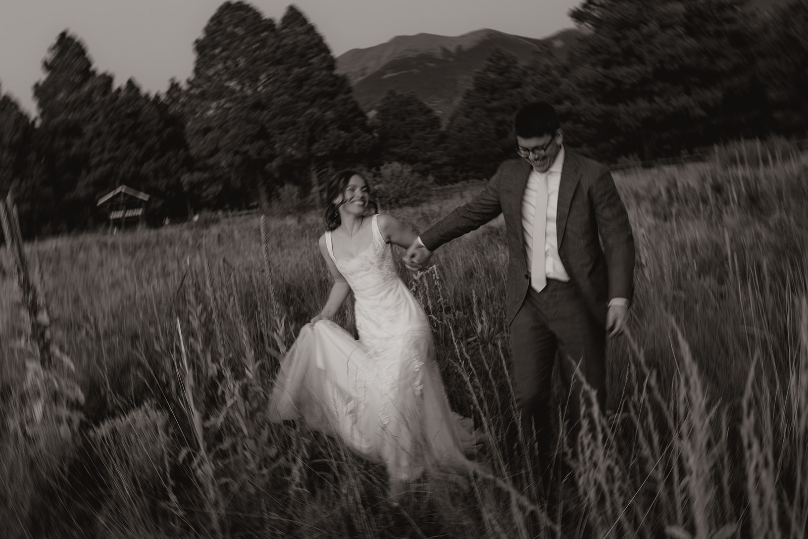 Newly married couple walking through tall grass and playing together