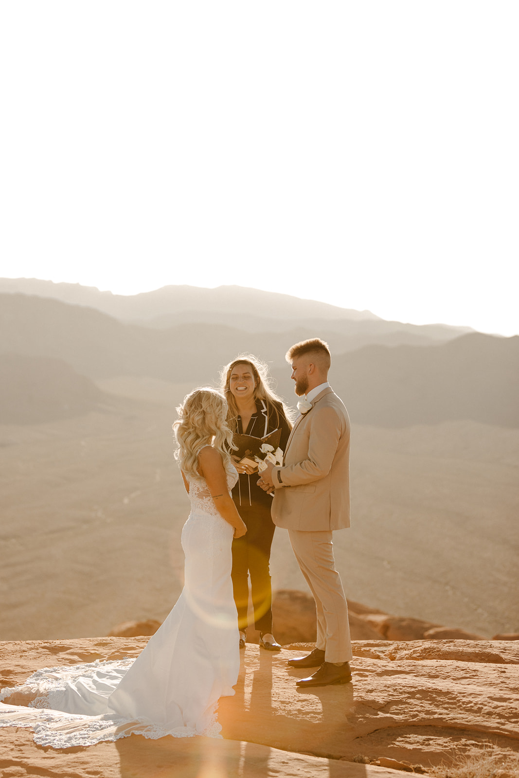 Intimate ceremony moment during an Arizona elopement, with vows exchanged on a sunlit desert cliff.