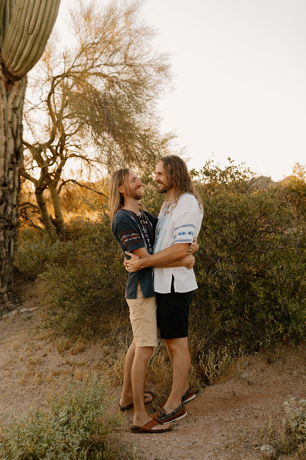 Two grooms embrace at sunset after their intimate Arizona elopement