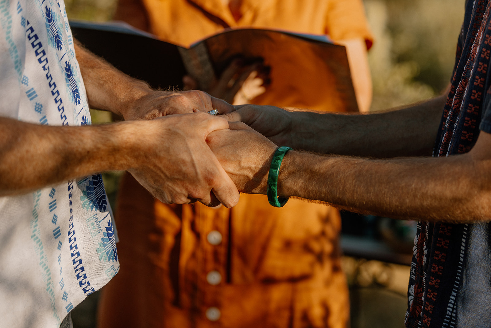 Grooms holding hands while listening to each other's vows during Arizona adventure elopement