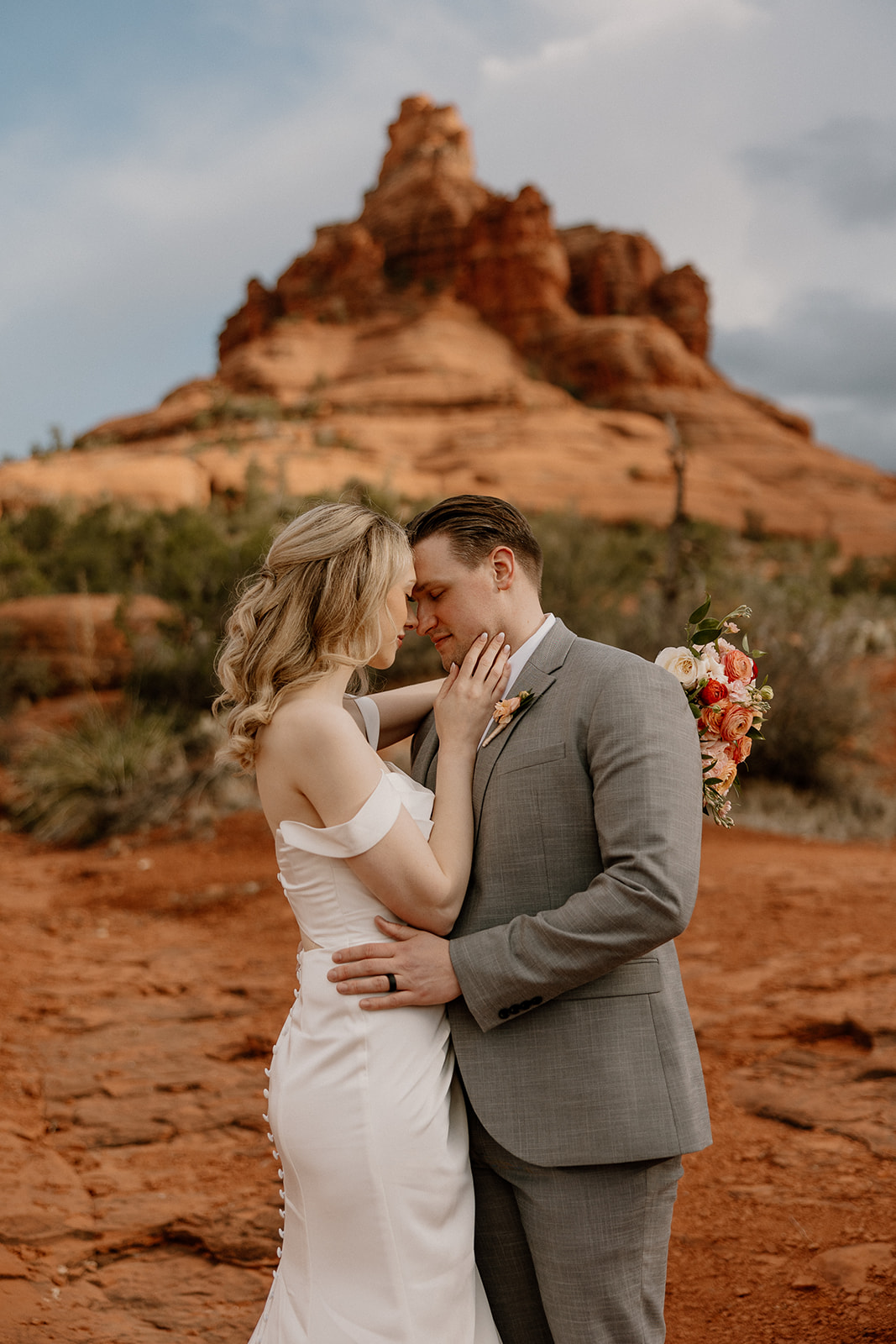 Bride and groom sharing a quiet moment in front of Bell Rock after their romantic Arizona elopement.