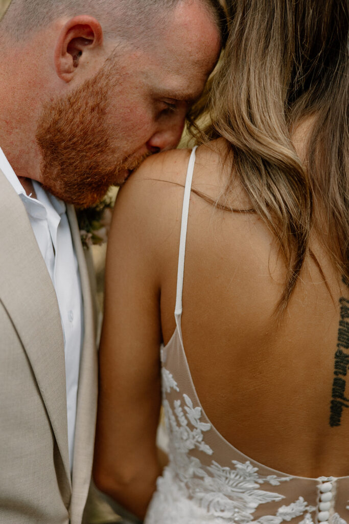 Close-up of a tender kiss on the bride’s shoulder, capturing the intimacy and connection found in elopements.
