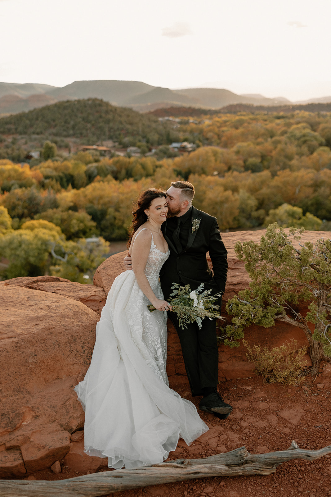 Wrapped in sunset light, the couple shares a quiet moment on the edge of the cliffs during their arizona adventure elopement.