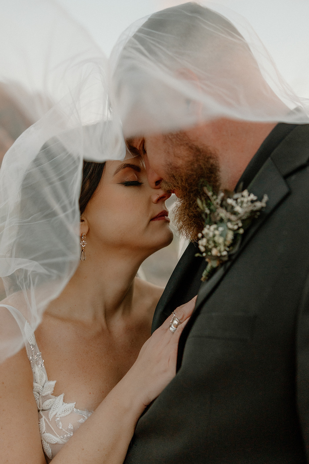 Couple embracing under bride's veil