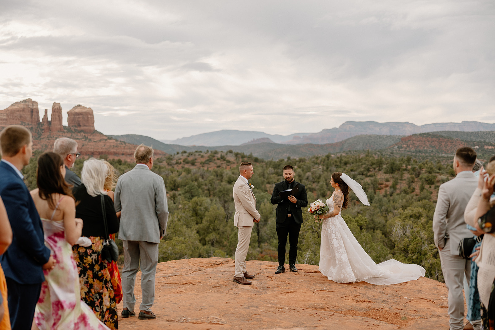 Bride and groom on top of Arizona red rocks during ceremony