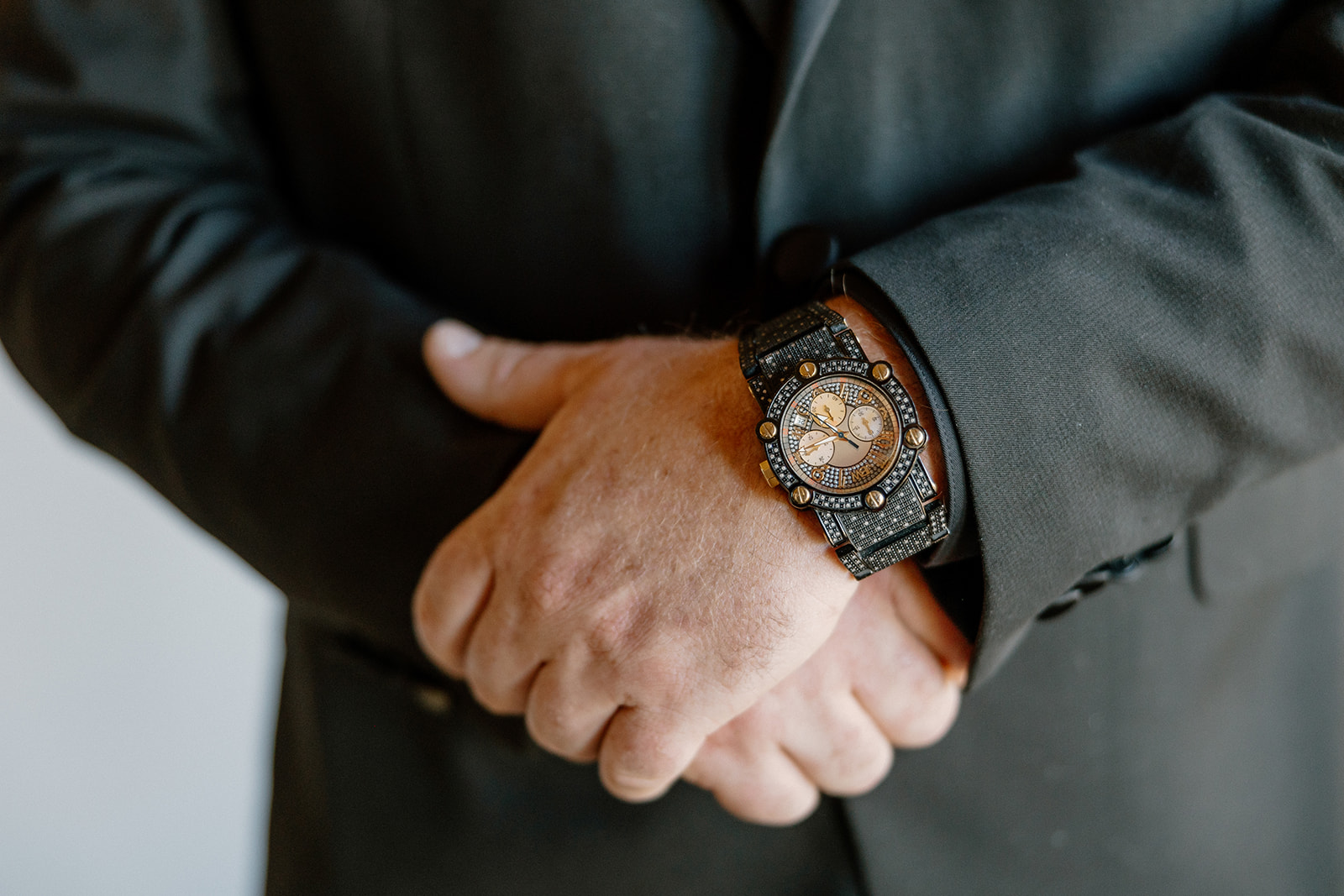 Groom wedding attire detail shot of a bold black wristwatch paired with an all-black suit, styled for a modern desert elopement.
