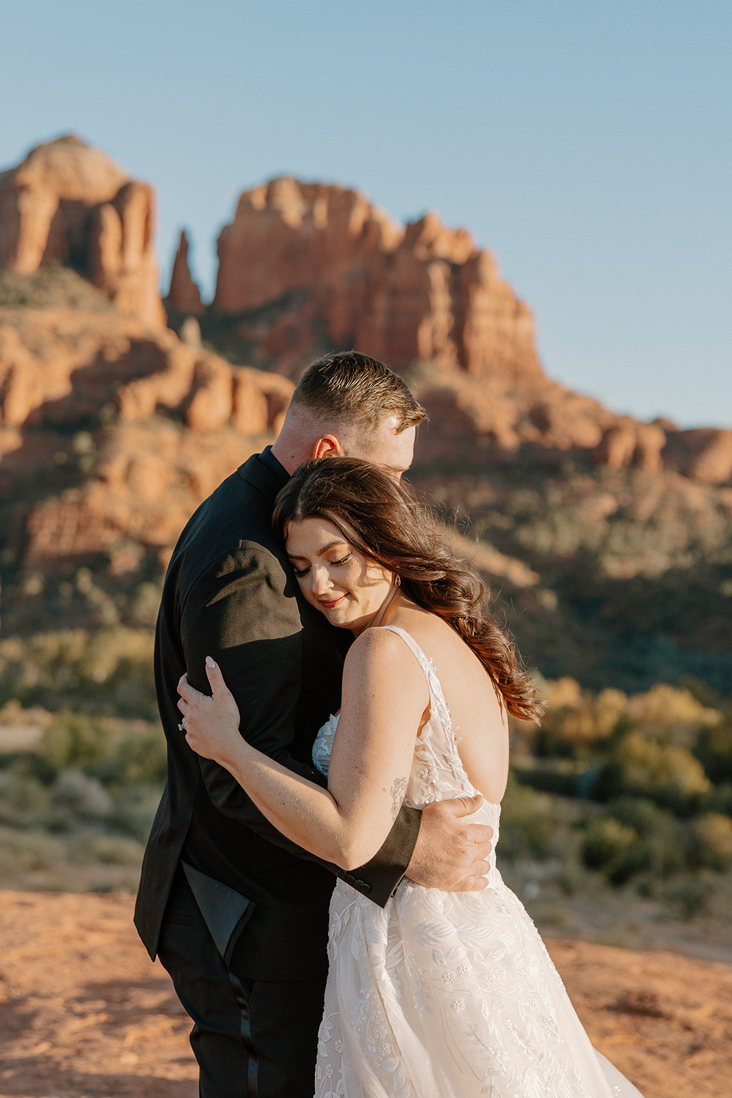 Bride hugs her groom in celebration after committing to one another in desert elopement. Their intimate sunset wedding proves what is the best time to elope for breathtaking views and incredible light